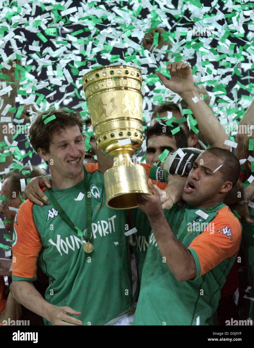 Dpa) - Bremen Kapitän Frank Baumann (L) und sein brasilianischer  Teamkollege Ailton (R) erhöhen den DFB-Pokal (deutscher Fußball Bund Cup)  vor ihren jubilierende Teamkollegen. Deutsche Liga Meister Werder Bremen  gewinnt die 61.