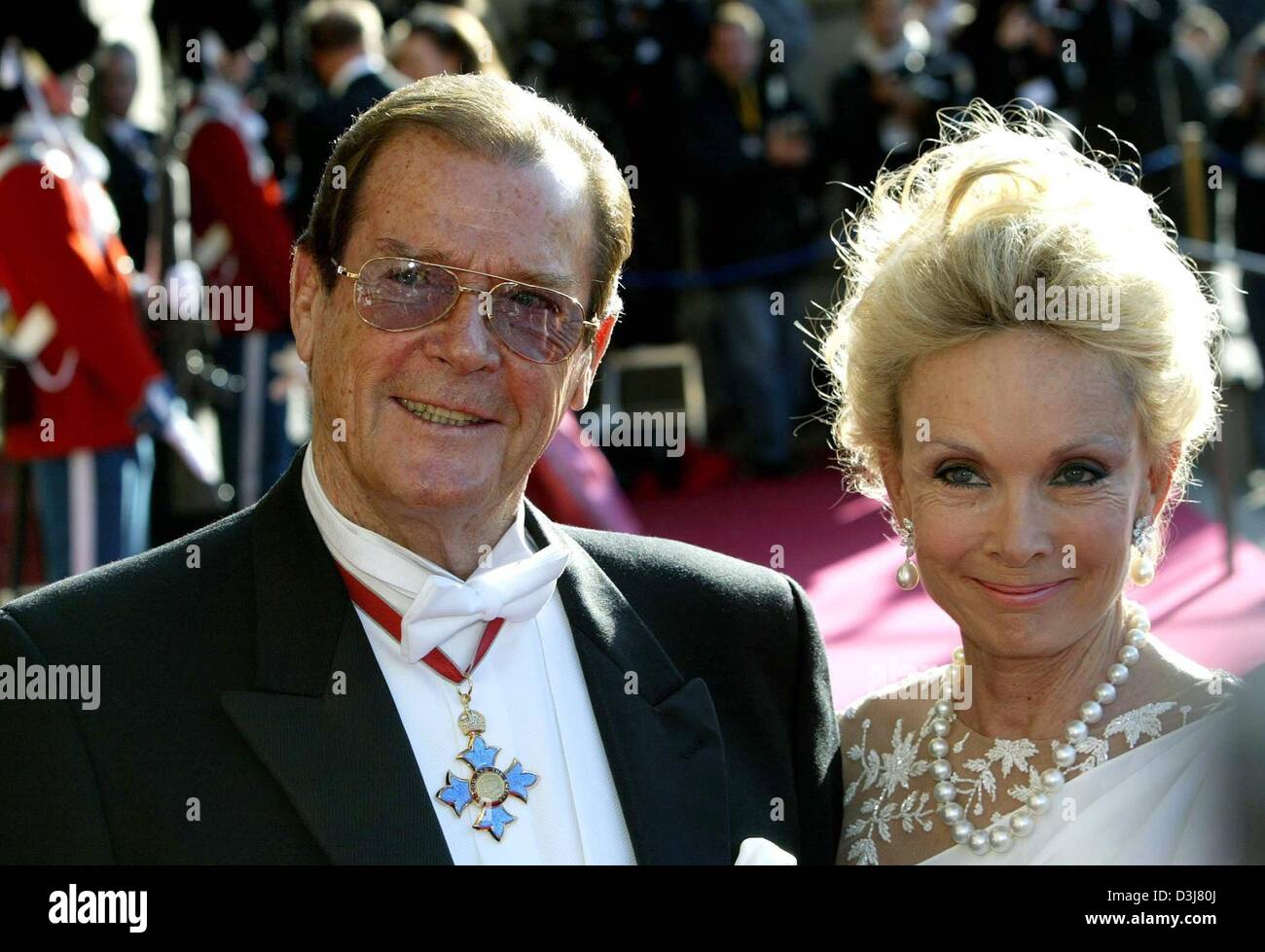 (Dpa) - am Vorabend der Hochzeit von Kronprinz Frederik von Dänemark und Mary Donaldson, britische Schauspieler Sir Roger Moore und seine Frau Lady Kristian Moore kommen für eine Gala am Königlichen Theater in Kopenhagen, 13. Mai 2004. Stockfoto