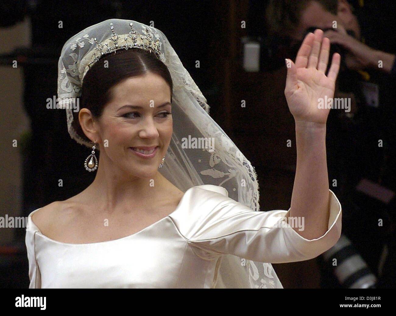 (Dpa) - Mary Donaldson, Braut des dänischen Kronprinzen Frederik, lächelt und Wellen ihre Hand wie sie aussieht gekleidet in ihrem Brautkleid vor der Kathedrale in Kopenhagen, Dänemark, Freitag, 14. Mai 2004. Die kirchliche Trauung von Kronprinz Frederik und Mary Donaldson aus Australien hat heute begonnen. Mitglieder aller europäischen Königshäusern zählen zu den 800 geladenen Gästen, die an teilnehmen Stockfoto