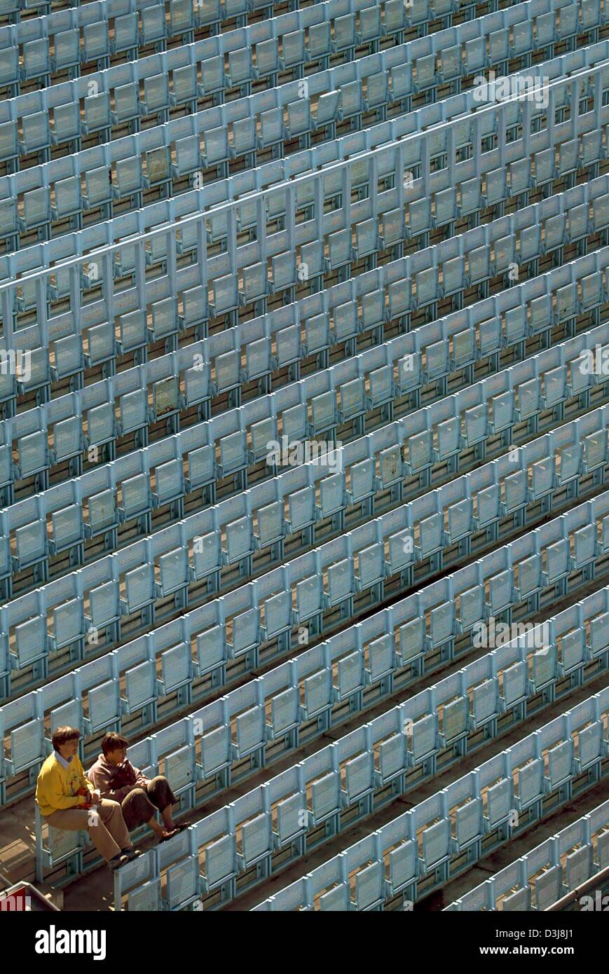 (Dpa) - zwei Tennis-Fans auf der Tribüne neben dem Centre Court sitzen und warten auf den Beginn der ersten German Open Spiele in Berlin, Deutschland, 5. Mai 2004. Das Turnier endet mit dem Finale am Sonntag. Stockfoto
