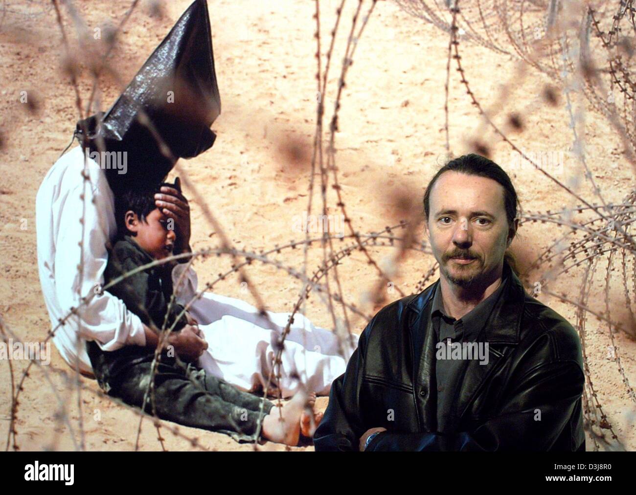 (Dpa) - steht der französische Fotograf Jean-Marc Bouju vor seiner preisgekrönten Foto des World Press Photo-Wettbewerbs 2004 in Hamburg, Deutschland, 28. April 2004. Das Foto wurde von einer internationalen Jury aus 63.093 Einträge ausgewählt. Es zeigt einen inhaftierten irakischen Mann, der seinen vier - jährigen Sohn auf dem Arm, in einem Gefangenenlager für Kriegsgefangene in der Nähe von Nadschaf, Irak hält. Mehr als 50 der Stockfoto