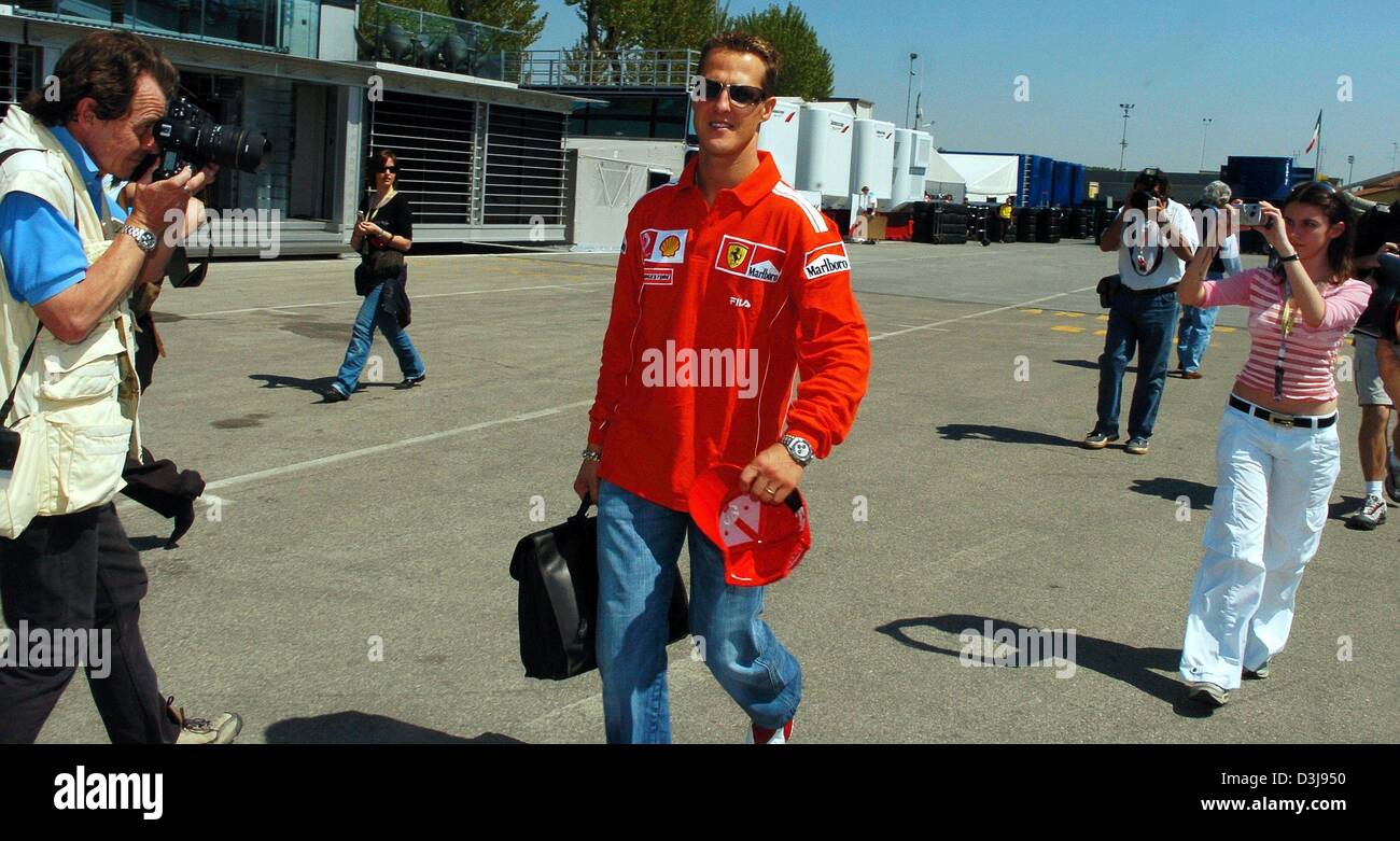 (Dpa) - deutscher Formel-1-Weltmeister Michael Schumacher (Ferrari-Team) ist umringt von Fotografen bei seiner Ankunft an der Rennstrecke "Enzo e Dino Ferrari" in Imola, Italien, 22. April 2004. Die erste europäischen Rennen der F1-Saison stattfinden in Imola mit San Marino Grand Prix. Stockfoto