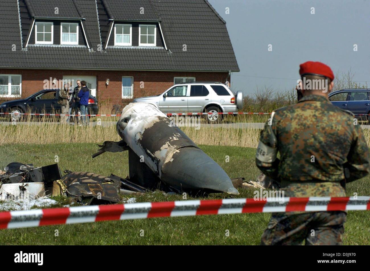 (Dpa) - ein Soldat bewacht das Wrack von zwei deutsche Tornado-Kampfjets, die in der Luft in der Nähe der Stadt Garding, Norddeutschland, am Mittwoch, 21. April 2004 kollidierte. Zwei Besatzungsmitglieder wurden bei dem Absturz getötet, aber zwei andere waren in der Lage, Sicherheit Fallschirm, teilte die Polizei mit. Stockfoto