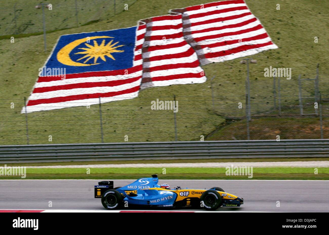 (Dpa) Die spanische Formel 1 Piloten Fernando Alonso Rennen während des freien Trainings auf der Sepang Rennstrecke in der Nähe von Kuala Lumpur auf Freitag, 19. März 2004, hinter ihm ist die Nationalflagge von Malaysia. Auf Sonntag, 21. März 2004 wird der Grand Prix von Malaysia im Gange. Stockfoto