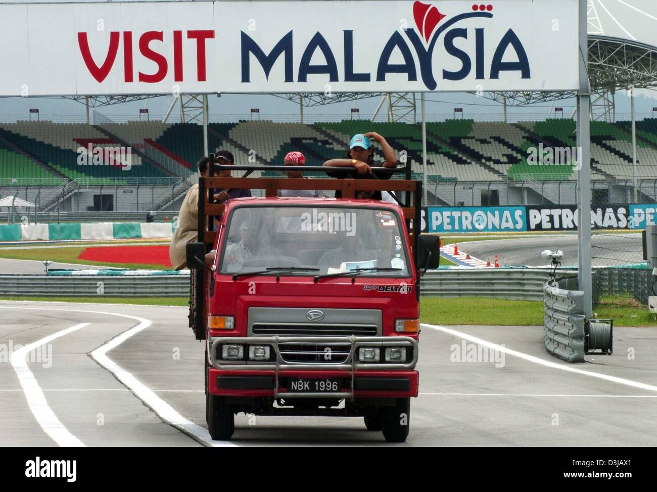 (Dpa) Malaysische Arbeitnehmer sind auf der Zielgeraden der Sepang Rennstrecke in der Nähe von Kuala Lumpur auf Mittwoch, 17. März 2004 transportiert. Auf Sonntag, 21. März 2004 wird der Grand Prix von Malaysia im Gange. Stockfoto