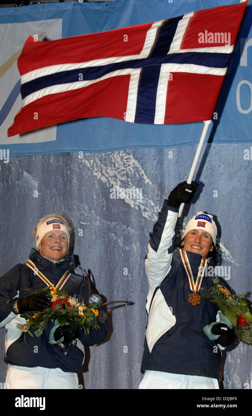 (Dpa) - Norwegens Hilde G. Pedersen und ihre Teamkollegin Marit Bjoergen (R), schwankt die norwegische Nationalflagge, jubeln und jubilate bei der Siegerehrung nach dem Gewinn der Goldmedaille in der Frauen 6 x 0, 9 Kilometer Langlauf Team Sprint-Event bei der nordischen Ski-WM in Oberstdorf, Deutschland, 24. Februar 2005. Norwegen gewann vor Finnnland und Russland. Stockfoto