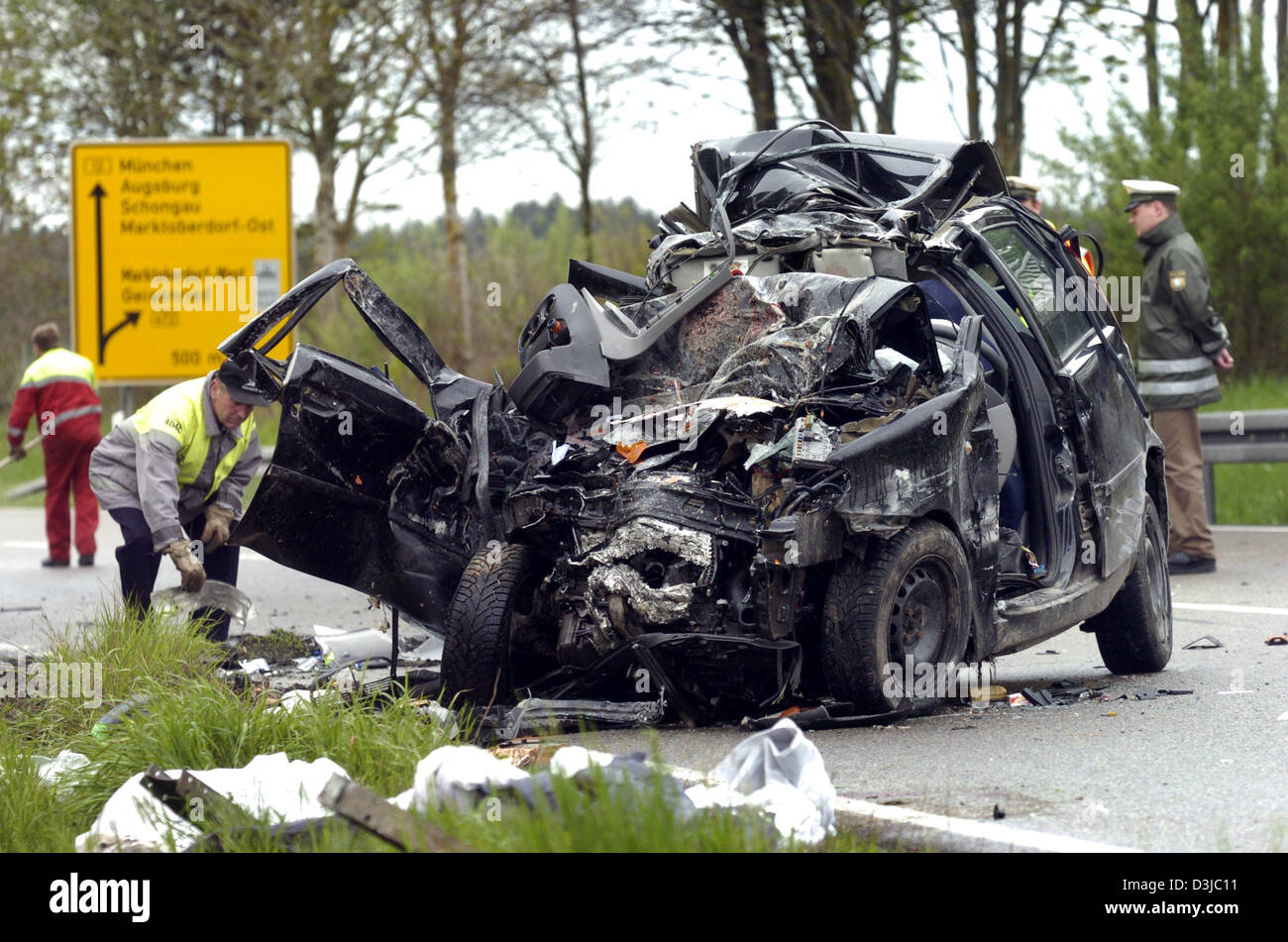 (Dpa) - Polizisten sichern Spuren nach einem tödlichen Autounfall auf der Autobahn 12 bei Geisenried, Germany, 22. Mai 2005. Ein Auto mit zwei Frauen verlor Kontrolle bei Regenwetter und schlug ein Passagierbus. Zwei Frauen starben sofort, während 17 Passagiere wurden nur leicht verletzt. Die Autobahn war danach für mehrere Stunden gesperrt. Stockfoto