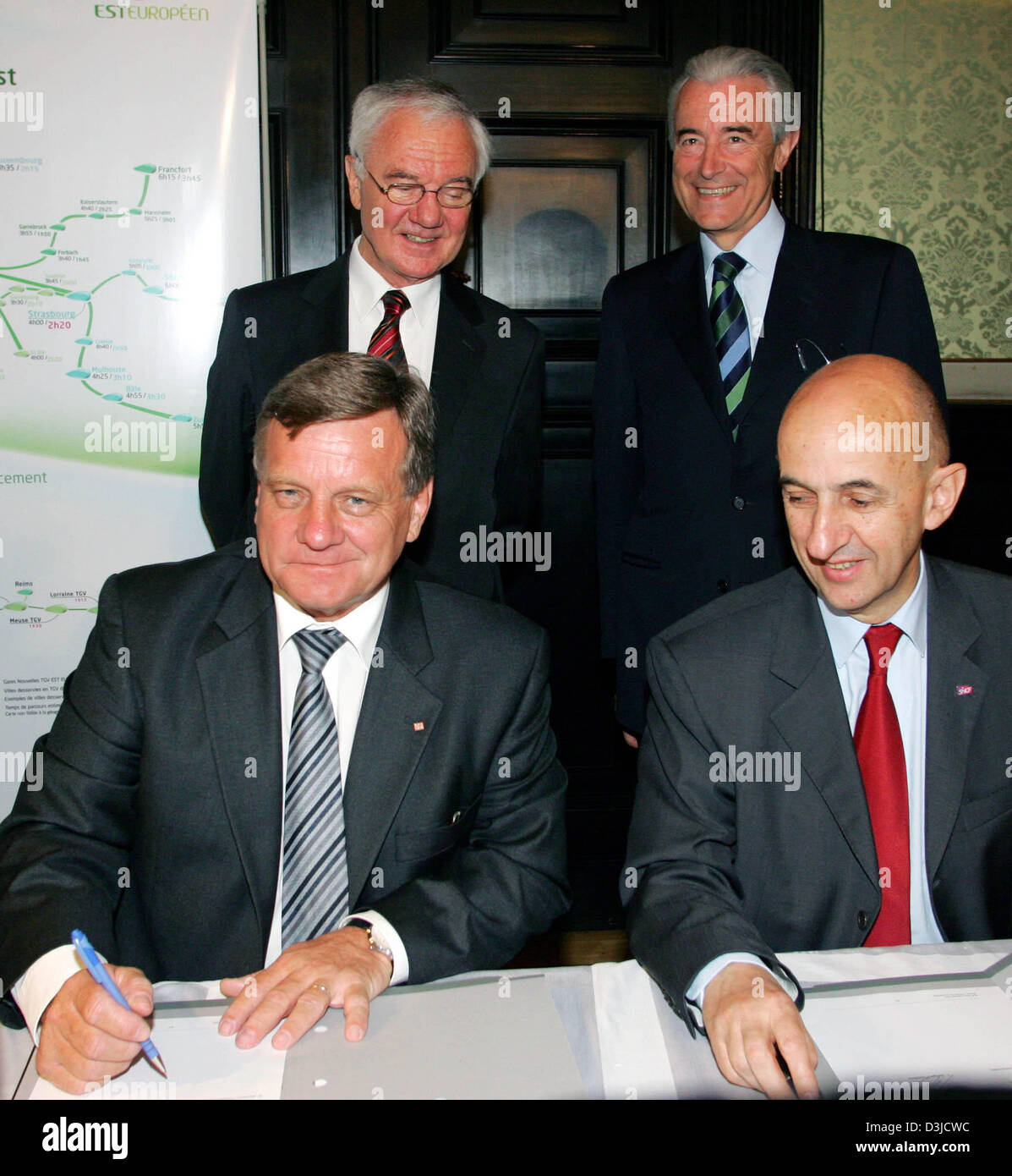 (Dpa) - Hartmut Mehdorn (L, vorn), Vorstandsvorsitzender der Deutschen Bahn AG und Louis Gallois (R, vorne), Präsident der französischen Eisenbahngesellschaft SCNF, unterschreiben Sie den Vertrag der Zusammenarbeit, während der deutsche Minister für Verkehr und Transport Manfred Stolpe (L, zurück) und sein französischer Amtskollege Gilles de Robien auf dem Bahnhof in Straßburg, Frankreich, Montag, 23. Mai 2005 betrachten. Ab 2007 MiG Stockfoto