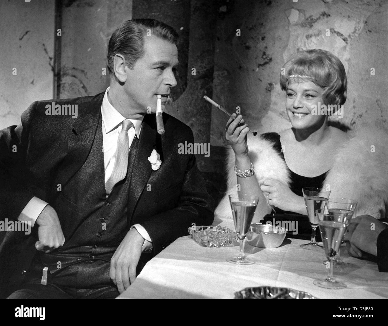 (Dpa-Datei) - österreichische Schauspieler O.W Fischer (L) und Maria Schell rauchen Zigaretten in einem Film noch aus "Das Riesenrad" (The Ferries Wheel) in Berlin, Deutschland, 13. Februar 1961. Maria Schell verstarb aufgrund einer Lungenentzündung im Alter von 79 in Kärnten, Österreich, Dienstag, 26. April 2005. Ihre große Karriere begann in den 1950er Jahren. Stockfoto