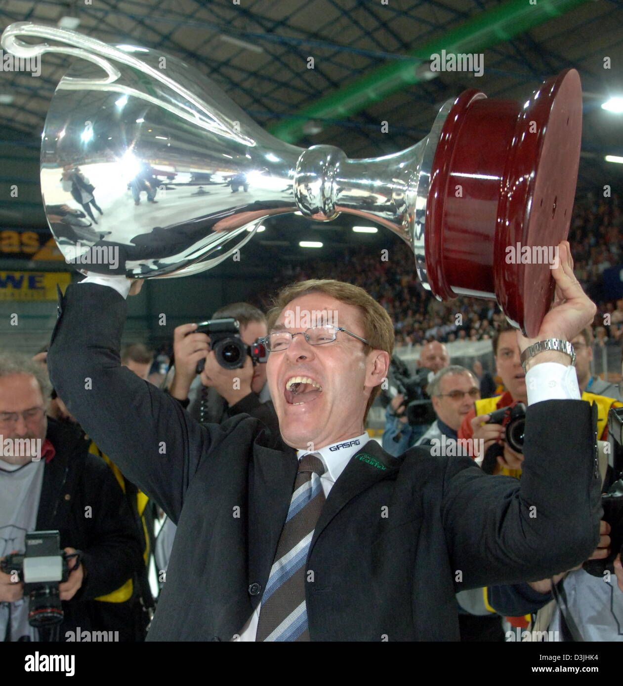 (Dpa) - der Berliner Trainer, Pierre Page, cheers und jubilates wie er die Trophäe hoch über seinen Kopf hält, nachdem seine Mannschaft der Deutsche Eishockey-Weltmeister-Titel in der deutschen Eishockey-Liga-Partie zwischen Eisbaeren Berlin und die Adler Mannheim in Berlin, 15. April 2005 gewann. Berlin bereits gewann die ersten beiden Spiele in der Serie und nun den neuen deutschen Eishockey-Meister mit mehr w Stockfoto
