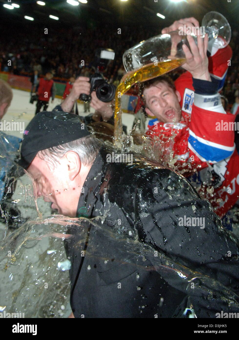 (Dpa) - der Berliner Sven Felski schüttet Bier über den Kopf des Co-Trainer Hartmut Nickel, nachdem seine Mannschaft gewann der Deutsche Eishockey-Weltmeister-Titel in der deutschen Eishockeyliga-match zwischen Eisbaeren Berlin und Adler Mannheim in Berlin, 15. April 2005. Berlin bereits gewann die ersten beiden Spiele in der Serie und nun den neuen deutschen Eishockey-Meister mit einem weiteren Sieg gegen Mannhe Stockfoto
