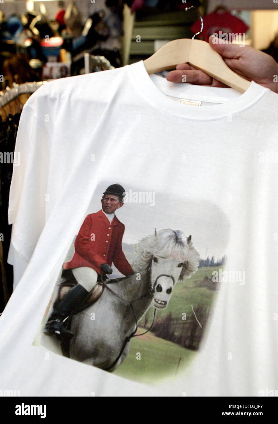(Dpa) - zeigt eine Verkäuferin ein T-shirt die eine satirische Darstellung von Großbritanniens Prinz Charles zeigt sitzend auf einem Pferd in einem Geschäft in Windsor, UK, 6. April 2005. Prinz Charles und Camilla Parker Bowles gebührt Mi in Windsor auf Samstag, 9. April 2005. Stockfoto