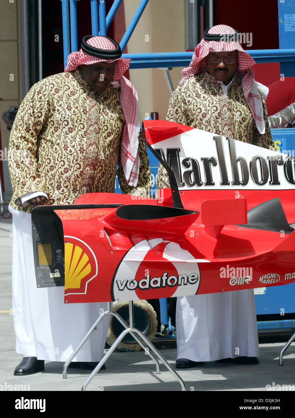 Zwei Scheichs sehen Sie die Motorabdeckung des neuen Ferrari Rennwagen in der Formel1 Rennstrecke in Bahrain, Mittwoch, 30. März 2005 in der Nähe von Manama, Bahrain. Der Grand Prix von Bahrain stattfinden am Sonntag, 3. April 2005. Stockfoto