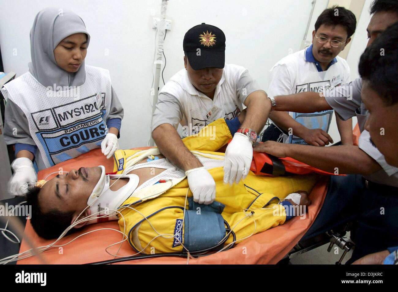 (Dpa) - Rennärzte und Krankenschwestern behandeln einen Simulation Patienten während einer Übung der F1 Gesundheitsdienste auf dem malaysischen Grand Prix Circuit, Donnerstag, 17. März 2005 in Sepang in der Nähe von Kuala Lumpur, Malaysia. Der Grand Prix von Malaysia findet am Sonntag, 20. März 2005. Stockfoto