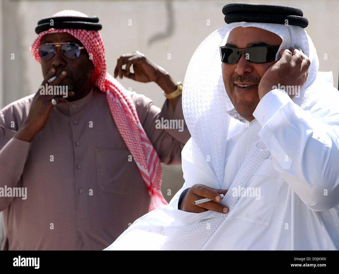 (Dpa) - zwei Fahrer tragen traditionelle Cothing und Sonnenbrillen für Kunden in Manama, Bahrain, 13. Februar 2005 warten. Stockfoto