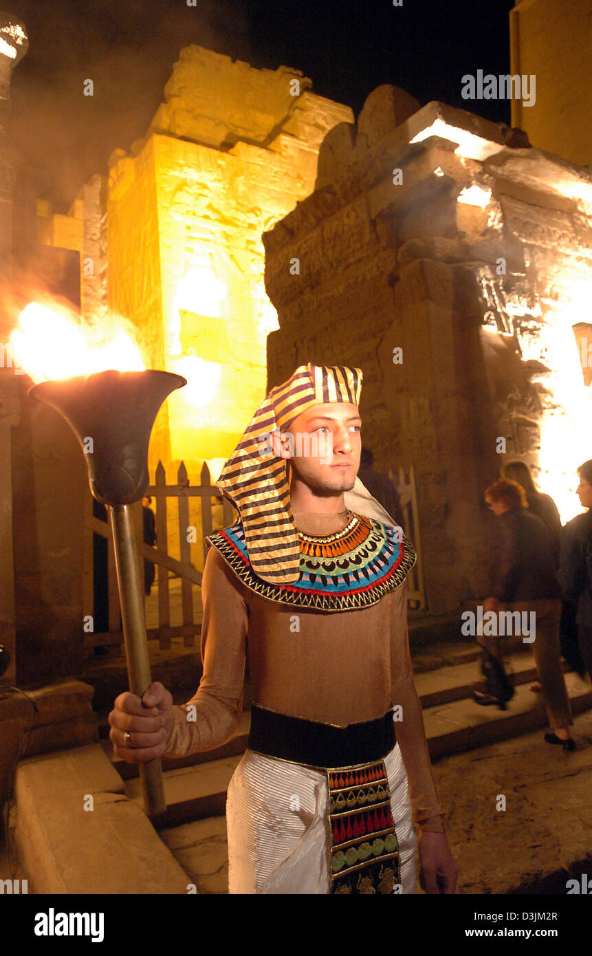 Dpa-Dateien) - ein junger ägyptischer Mann das traditionelle Kopftuch der  alten Ägypter, das Nemes-Kopftuch, hält eine Fackel während einer  Folklore-Abend am beleuchteten Tempel in der historischen Stadt von Luxor,  Ägypten, 22. November