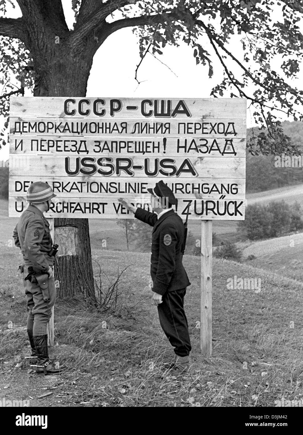 (Dpa) - Grenze Pollicemen sprechen eine Hinweistafel an der Demarkationslinie, die Grenze zwischen den USA und der sowjetischen Besatzungszonen in Deutschland, am 3. Oktober 1946. Stockfoto