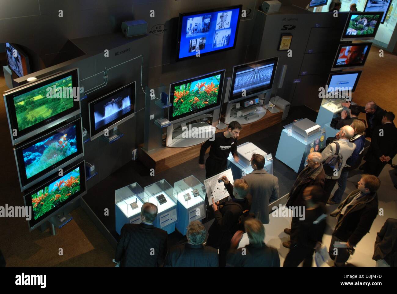 (Dpa) - Blick Besucher auf Panasonic Plasma-Bildschirme auf der Computermesse CeBIT in Hannover, Deutschland, 10. März 2005. 6.270 Aussteller präsentieren ihre Produkte auf der weltweit größten Computer und Telekommunikation Messe, die vom 10 März bis 16. März 2005 läuft. Stockfoto