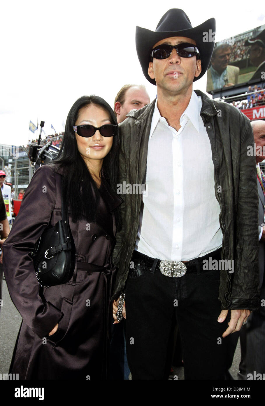 (Dpa) - U.S.-Schauspieler Nicolas Cage und seiner dritten Frau, ehemalige Kellnerin Alice Kim, Spaziergang über die Startaufstellung vor dem Grand Prix von Australien, Sonntag 06 März 2005 in Melbourne, Australien. Giancarlo Fisichella Italien gewann vor Rubens Barrichello aus Brasilien und Fernando Alonso Spanien. Stockfoto
