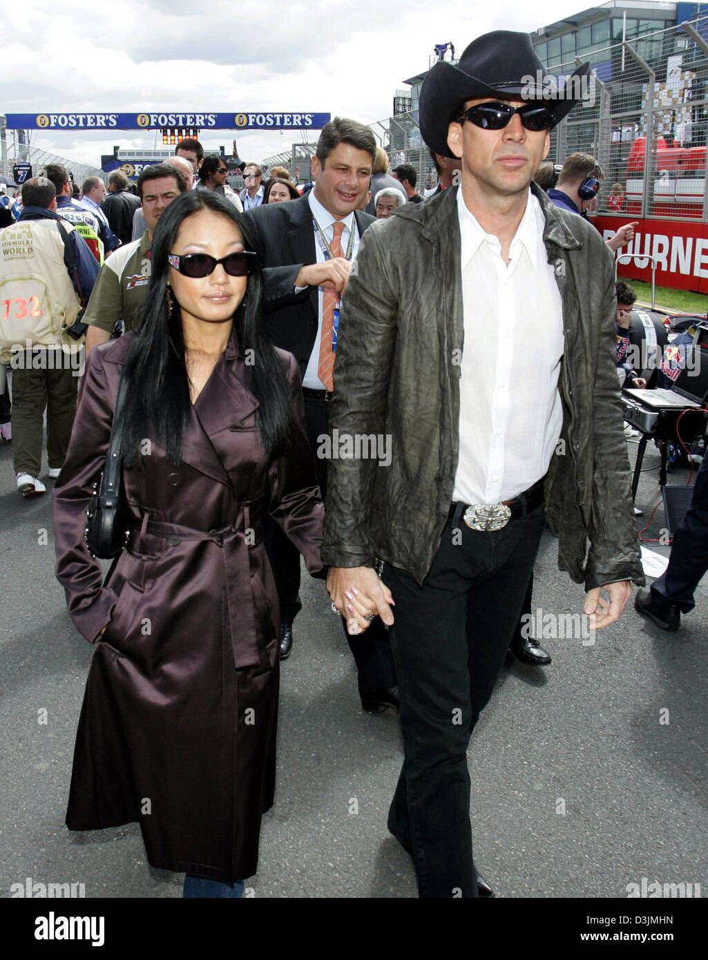 (Dpa) - U.S.-Schauspieler Nicolas Cage und seiner dritten Frau, ehemalige Kellnerin Alice Kim, Spaziergang über die Startaufstellung vor dem Grand Prix von Australien, Sonntag 06 März 2005 in Melbourne, Australien. Giancarlo Fisichella Italien gewann vor Rubens Barrichello aus Brasilien und Fernando Alonso Spanien. Stockfoto