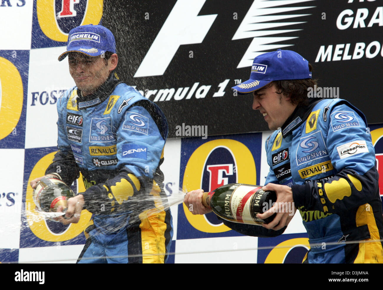 (Dpa) - italienischer Formel-1-Fahrer Giancarlo Fisichella (Renault) und seinem Teamkollegen Fernando Alonso (R) Spaniens genießen den Champagner auf dem Podium nach dem australischen Grand Prix in Melbourne, Australien, 6. März 2005. Italienische Formel 1 pilot Giancarlo Fisichella siegte vor brasilianischen Fahrer Rubens Barrichello und Fernando Alonso Spanien. Stockfoto