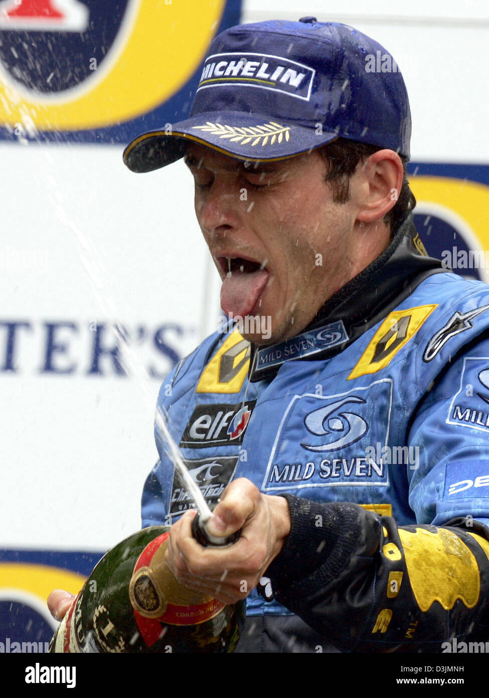 (Dpa) - Spritzer italienische Formel-1-Fahrer Giancarlo Fisichella (Renault) um mit einer Flasche Champagner auf dem Podium nach dem Gewinn der Australian Grand Prix in Melbourne, Australien, 6. März 2005. Fisichella siegte vor Brasilianer Rubens Barrichello und Fernando Alonso Spanien. Stockfoto