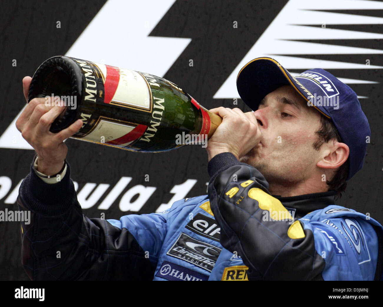 (Dpa) - Getränke italienische Formel-1-Fahrer Giancarlo Fisichella (Renault) aus einer Flasche Champagner auf dem Podium nach dem Gewinn der Australian Grand Prix in Melbourne, Australien, 6. März 2005. Fisichella siegte vor Brasilianer Rubens Barrichello und Fernando Alonso Spanien. Stockfoto