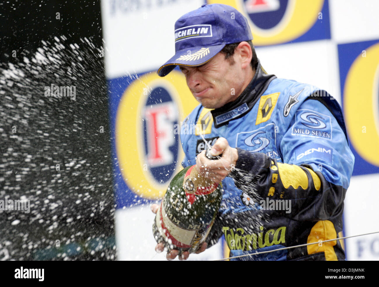 (Dpa) - Spritzer italienische Formel-1-Fahrer Giancarlo Fisichella (Renault) um mit einer Flasche Champagner auf dem Podium nach dem Gewinn der Australian Grand Prix in Melbourne, Australien, 6. März 2005. Fisichella siegte vor Brasilianer Rubens Barrichello und Fernando Alonso Spanien. Stockfoto