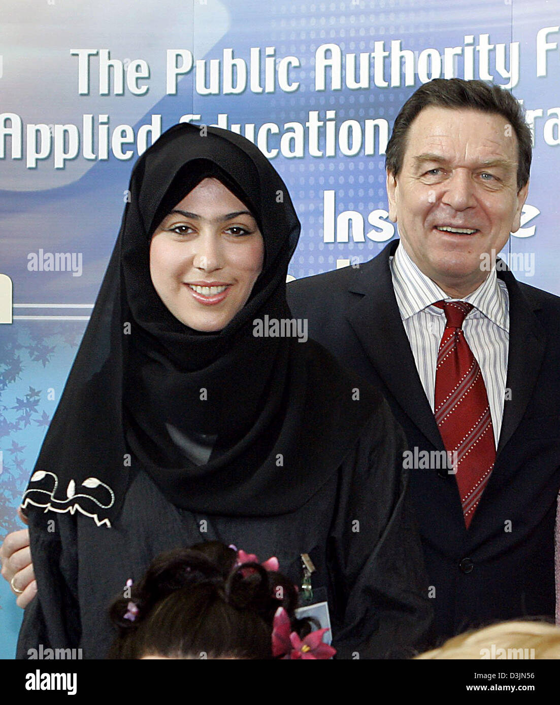 (Dpa) - Bundeskanzler Gerhard Schroeder lächelt, als er steht neben einer jungen Frau aus Kuwait während seines Besuchs am Institut für Berufsbildung, wo er sich über die Ausbildung informiert, und Ausbildung junger Frauen aus Kuwait in Kuwait-Stadt, Kuwait, 1. März 2005. Schröder ist auf einer einwöchigen Tour von sieben arabischen Ländern zur Steigerung Deutschlands Handel und polit Stockfoto