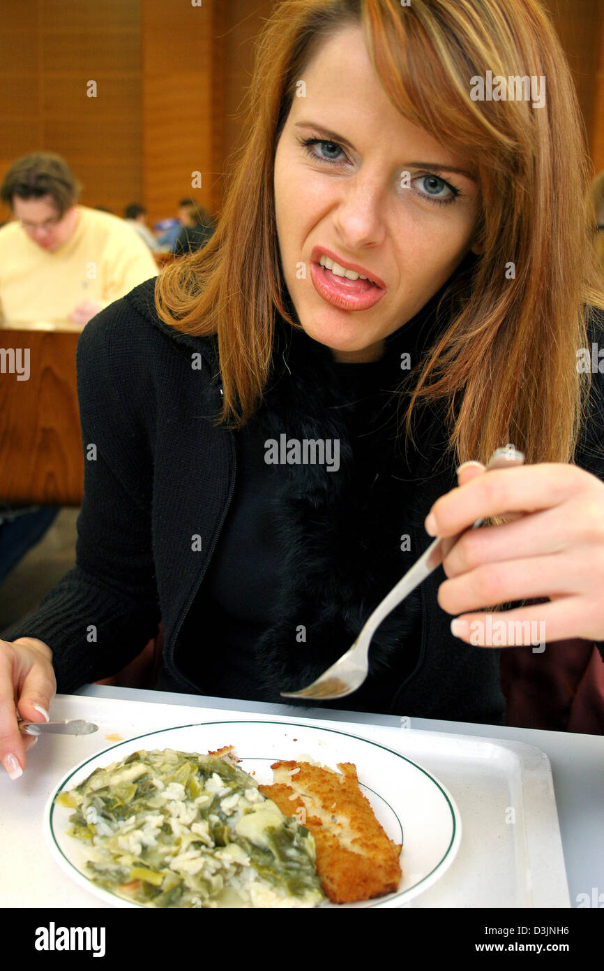 (Dpa) - ein Student zieht ein Gesicht, wie sie ihr Mittagessen aus der Kantine in der Mensa an der Goethe Universität in Frankfurt am Main, 11. Februar 2005 isst. Stockfoto