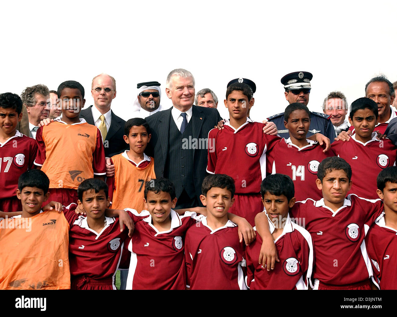 (Dpa) - deutsche Innenminister, Otto Schily (C), stellt mit dem Jugend-Fußball-Team für ein Gruppenbild in Manama, Bahrain, 13. Februar 2005. Unter anderem holte Schily über die Ausbildung von irakischen Polizisten von der deutschen Bundespolizei in den Vereinigten Arabischen Emiraten (VAE) und Bahrains Rolle in den Bau einer Polizei in Afghanistan während seines dreitägigen vi Stockfoto