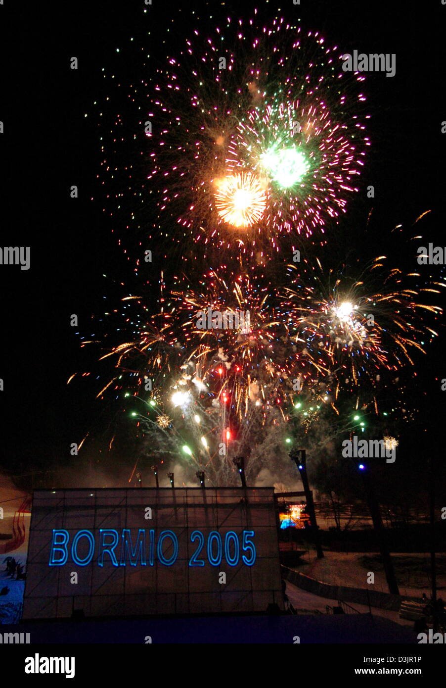 (Dpa) - explodieren buntes Feuerwerk über der Piste mit einem beleuchtet-Neonzeichen, das "Bormio 2005" während der feierlichen Eröffnung der alpinen Ski-WM in Bormio, Italien, 28. Januar 2005 liest. Die WM läuft bis zum 13. Februar 2005. Stockfoto