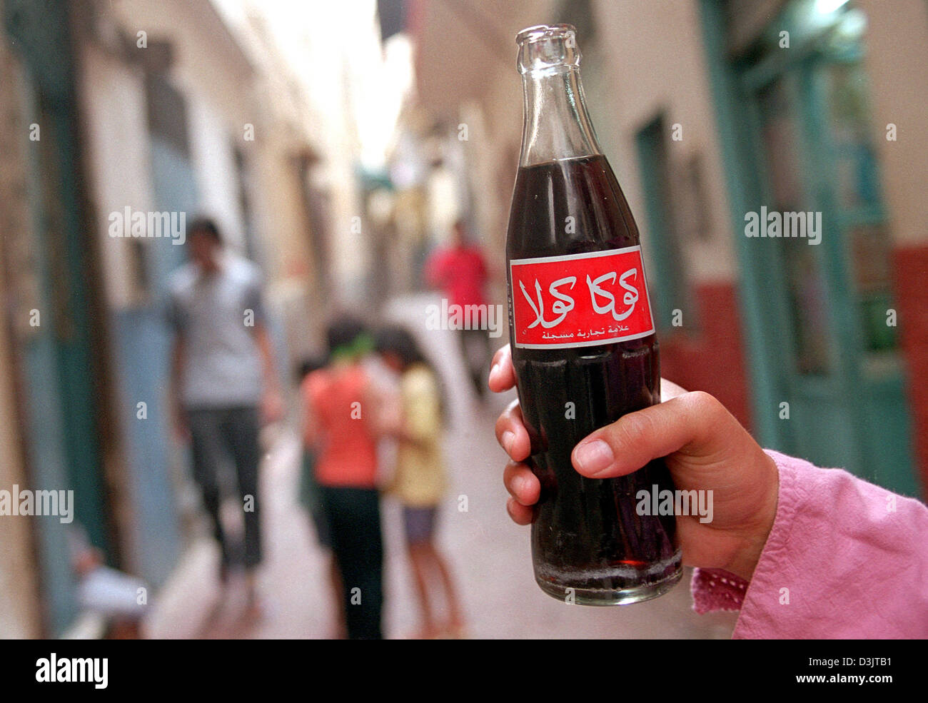 (Dpa) - eine Hand hält eine Flasche Coca Cola mit arabischer Inschrift im Medina Stadtteil der alten Stadt Tanger, Marokko, 16. September 2004. Stockfoto