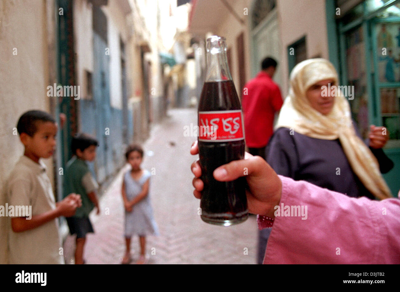 (Dpa) - eine Hand hält eine Flasche Coca Cola mit arabischer Inschrift im Medina Stadtteil der alten Stadt Tanger, Marokko, 16. September 2004. Stockfoto