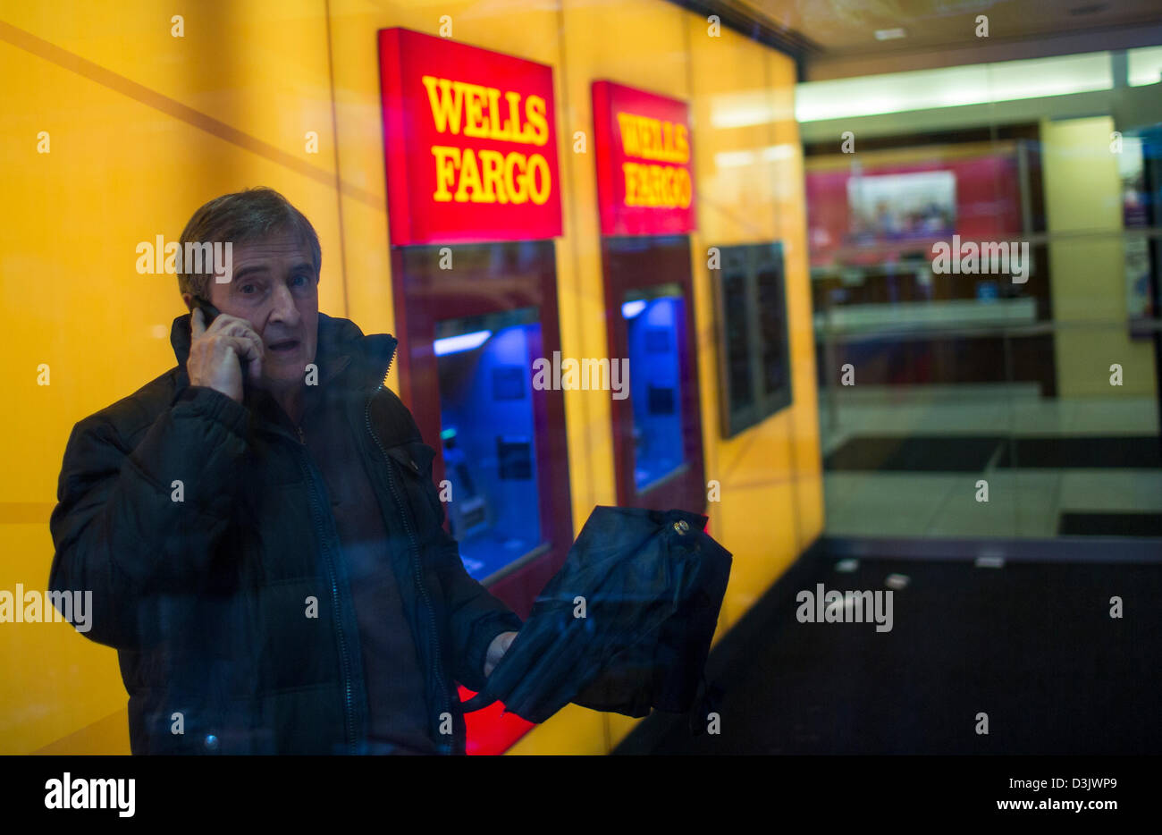 Ein Mann macht einen Anruf innerhalb einer Wells Fargo Bank-Büro in New York City. Stockfoto