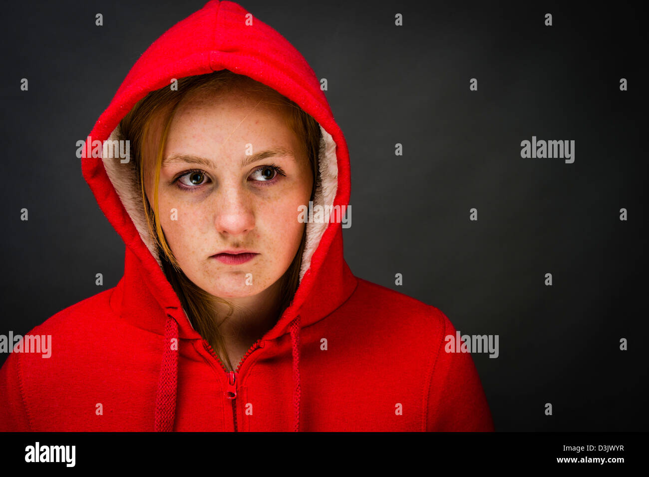 Eine stimmungsvolle sulky 16, 17 Jahre alten roten Haaren Sommersprossen konfrontiert Teenager-Mädchen, tragen einen Hoodie UK Stockfoto