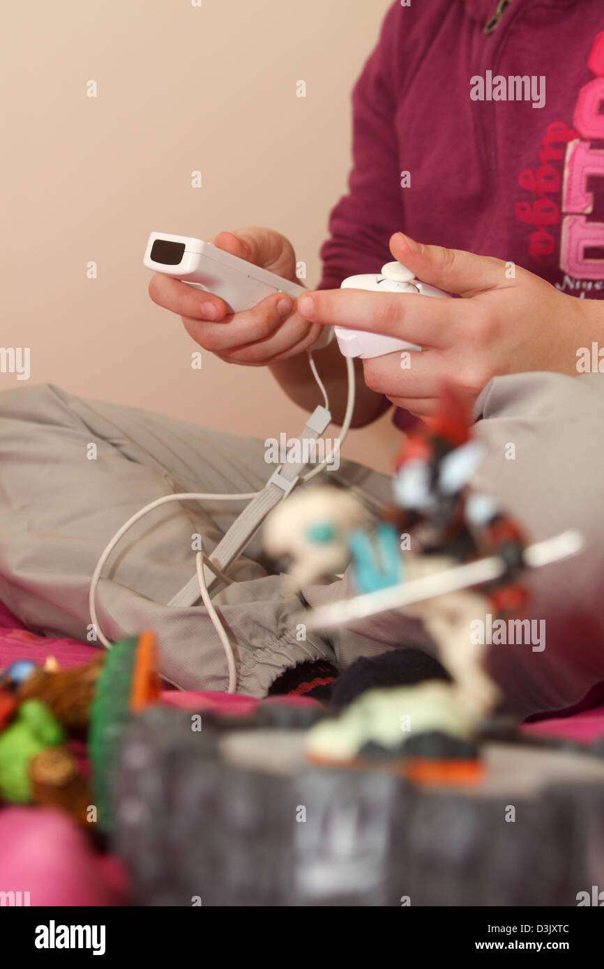Junges Mädchen Skylanders video Spiel auf Nintendo Wii mit Portal und Charakter-Figuren Stockfoto