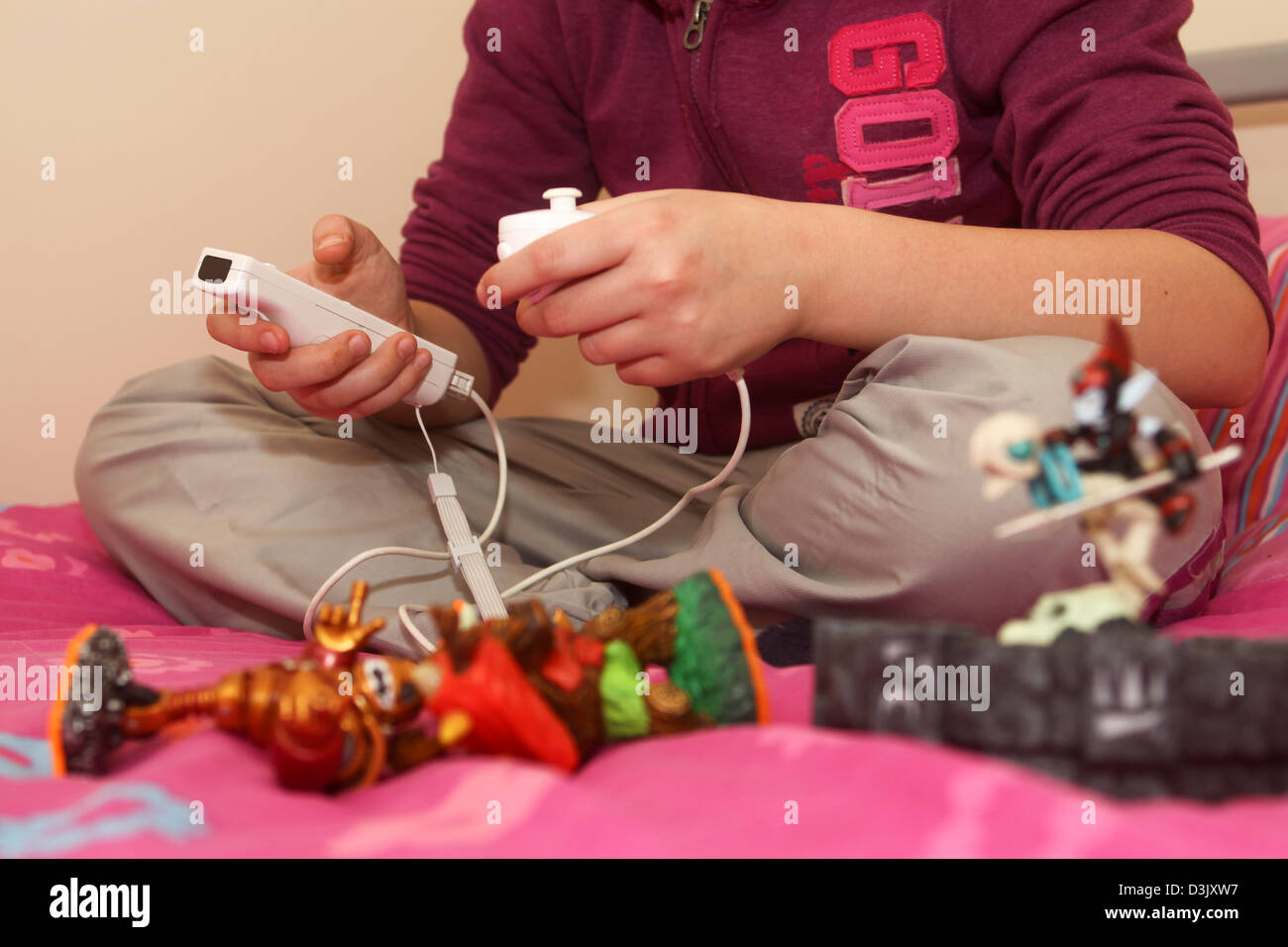 Junges Mädchen Skylanders video Spiel auf Nintendo Wii mit Portal und Charakter-Figuren Stockfoto