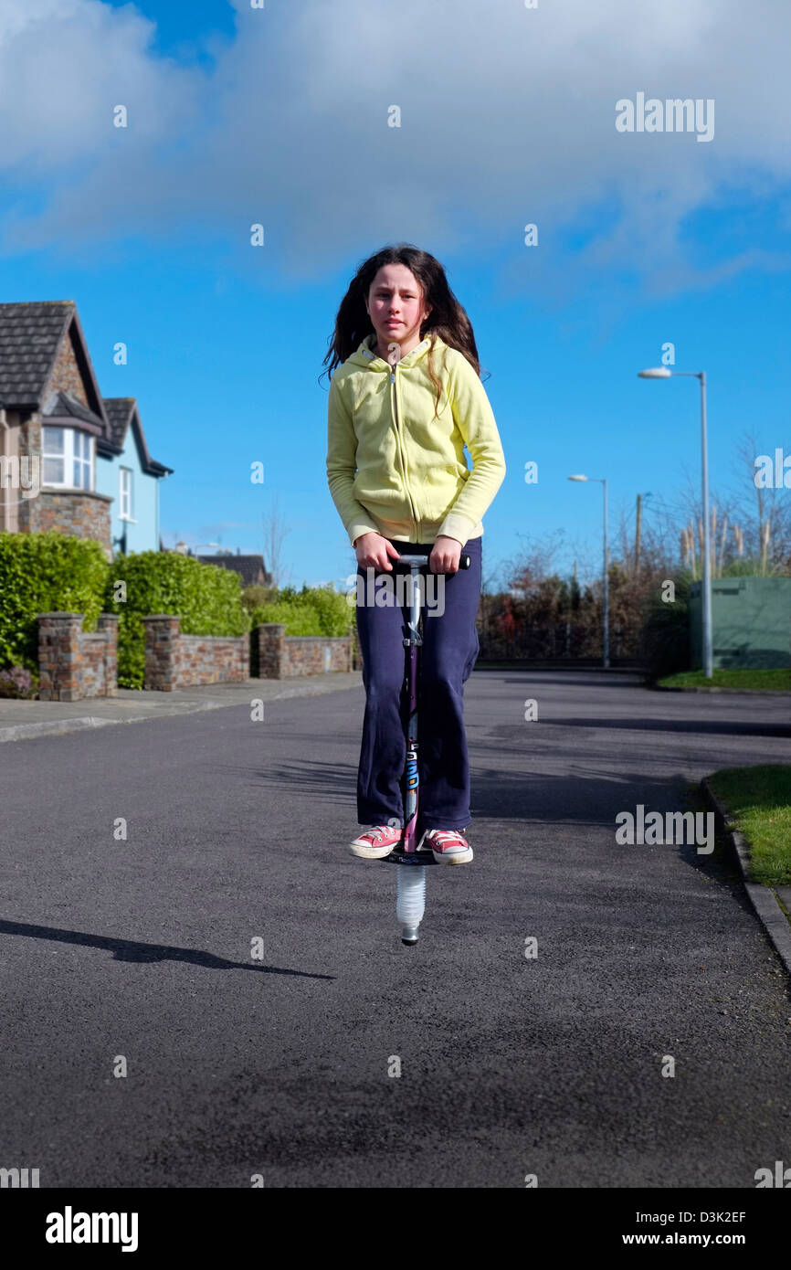 Mädchen auf Pogo Stick, Kind Youngster springen weibliche Irland Stockfoto