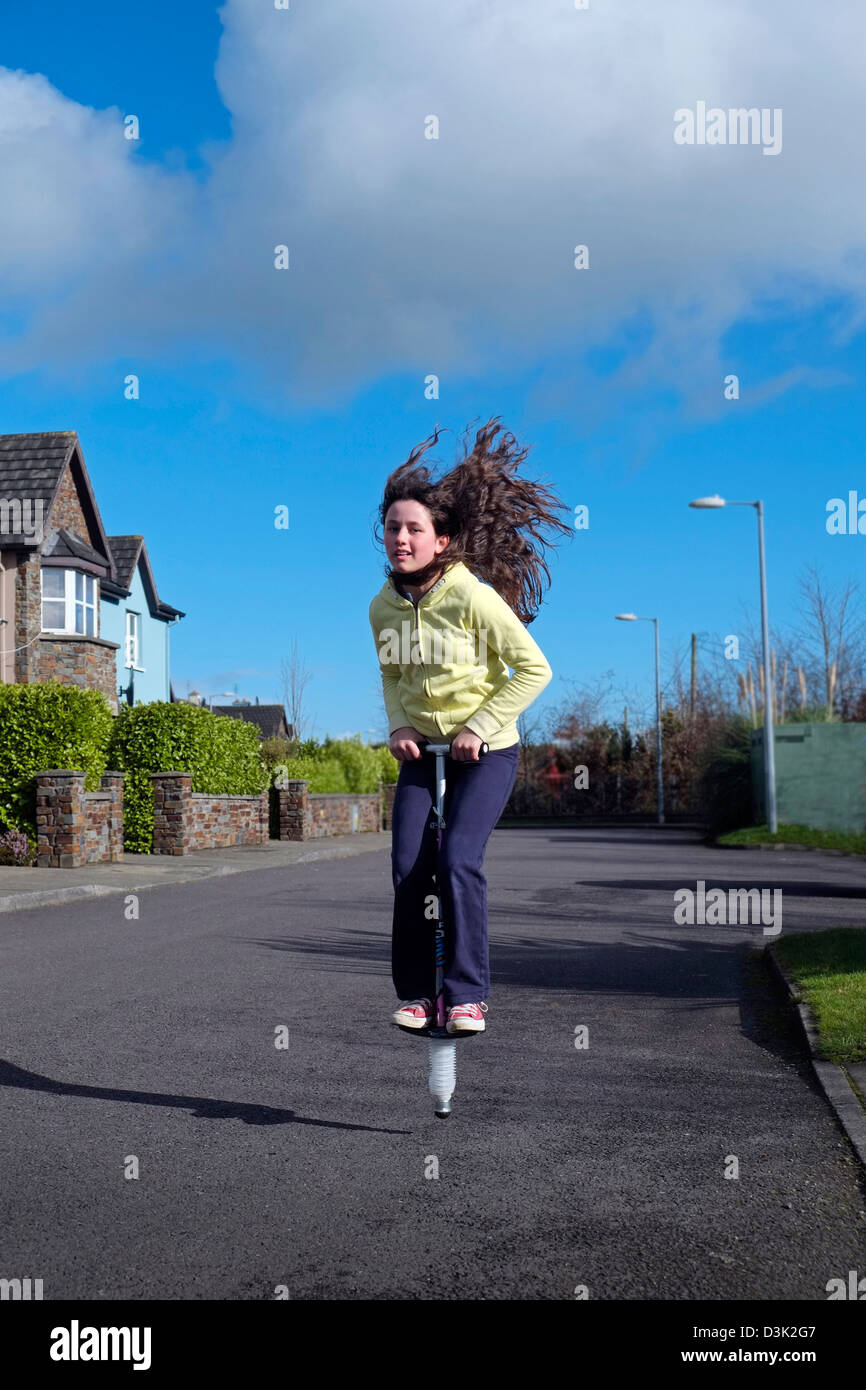 Mädchen Kind Kind Schulmädchen auf Pogo Stick Irland Prellen Stockfoto