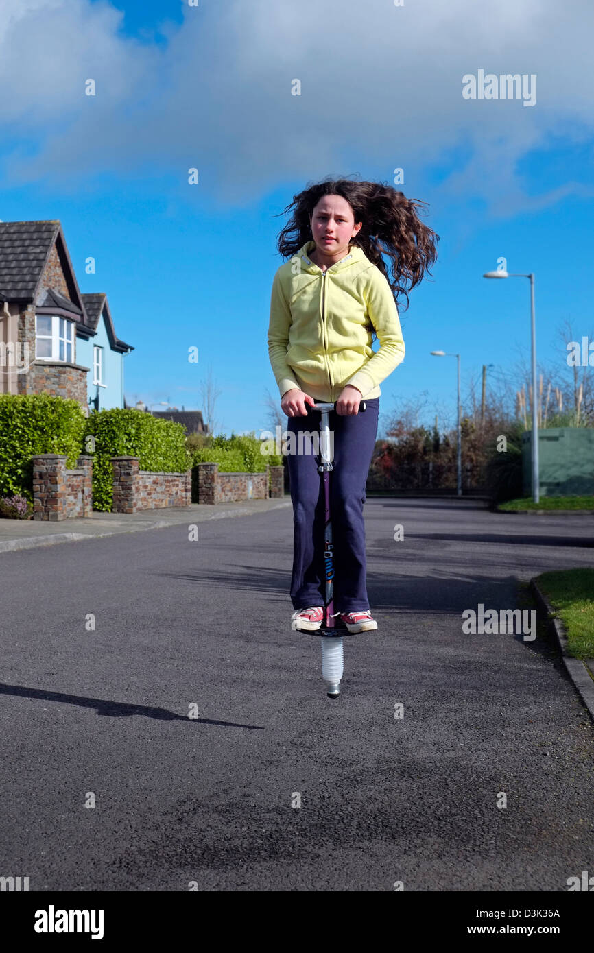 Mädchen auf Pogo Stick weibliche Kind Youngster Irland springen irische Kind Stockfoto