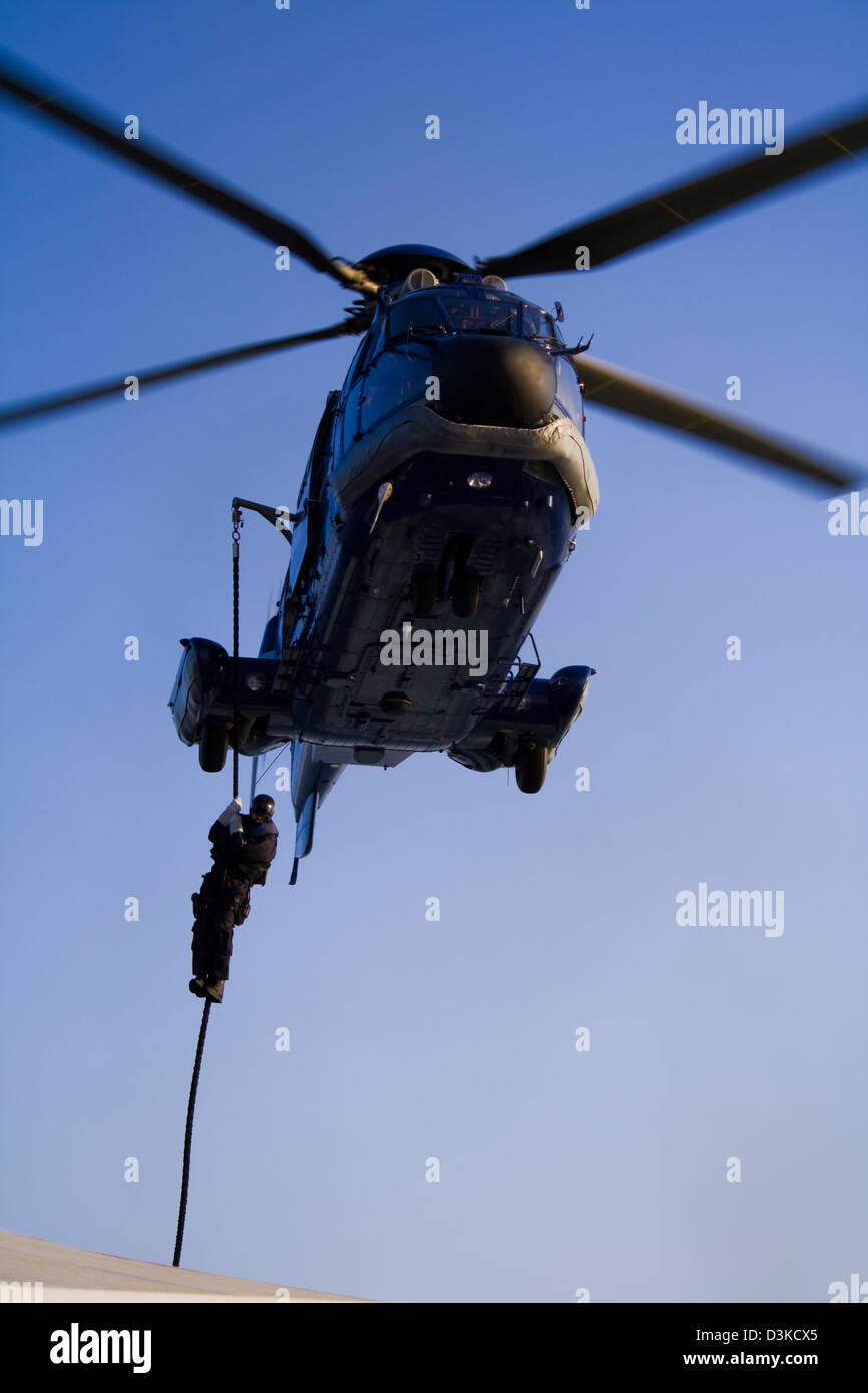 Spezialeinheiten (SWAT) Mitglied auf Seil von einem Hubschrauber (eine französische aus AS 332 L1 Super Puma Euro Copter) absteigend Stockfoto
