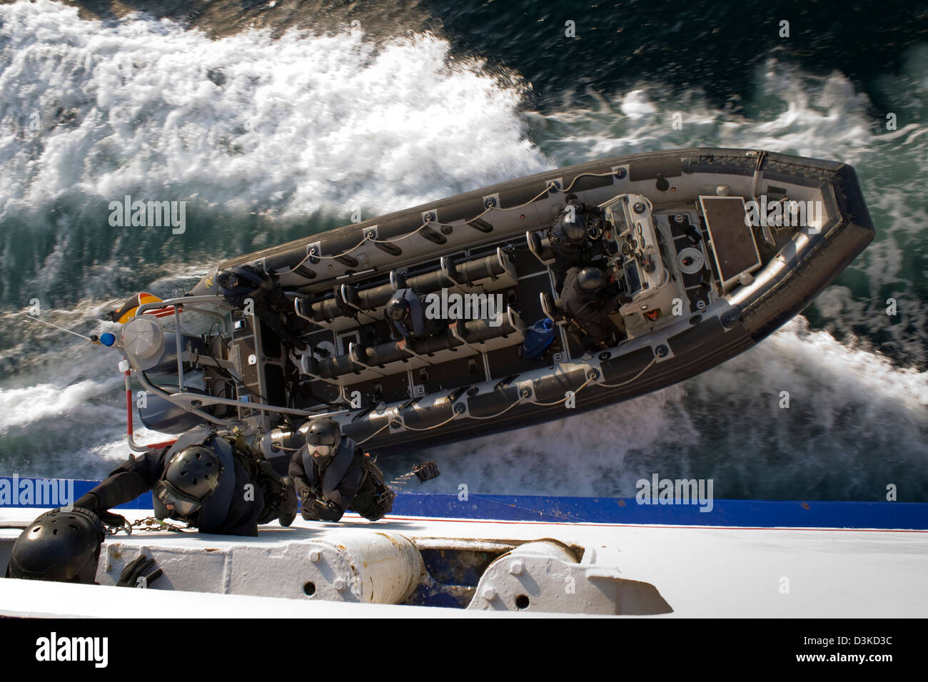Ein SWAT (Special Forces) aufblasbare Schlauchboot entfernt wie Agenten an der Seite der beweglichen Schiff klettern. Stockfoto