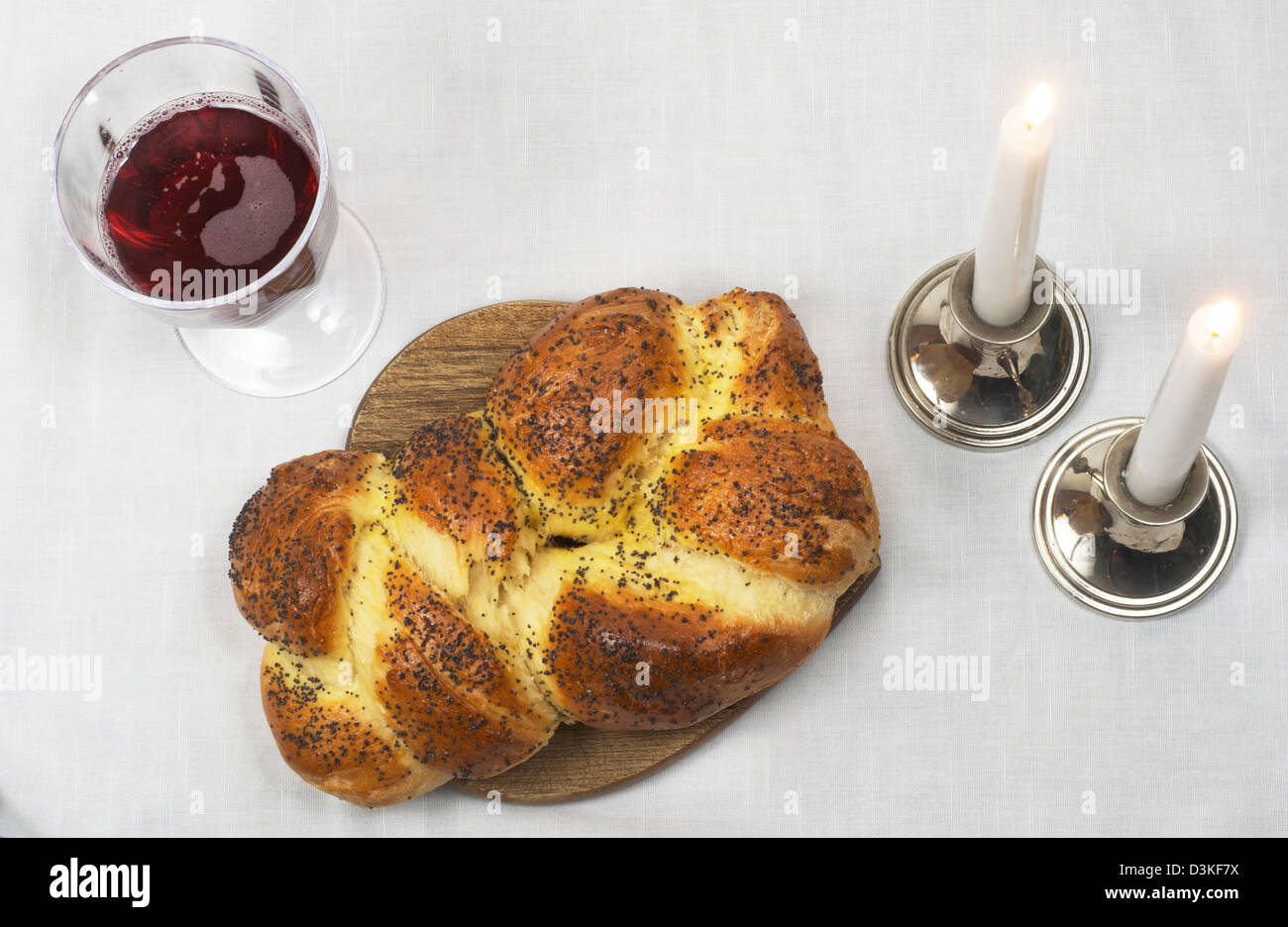 Shabbat Mahlzeit des Challah, Glas Wein, mit zwei Kerzen im Kerzen angezündet. Stockfoto Shabbat Mahlzeit des Challah, Glas Wein, mit zwei Kerzen im Kerzen angezündet. Stockfoto