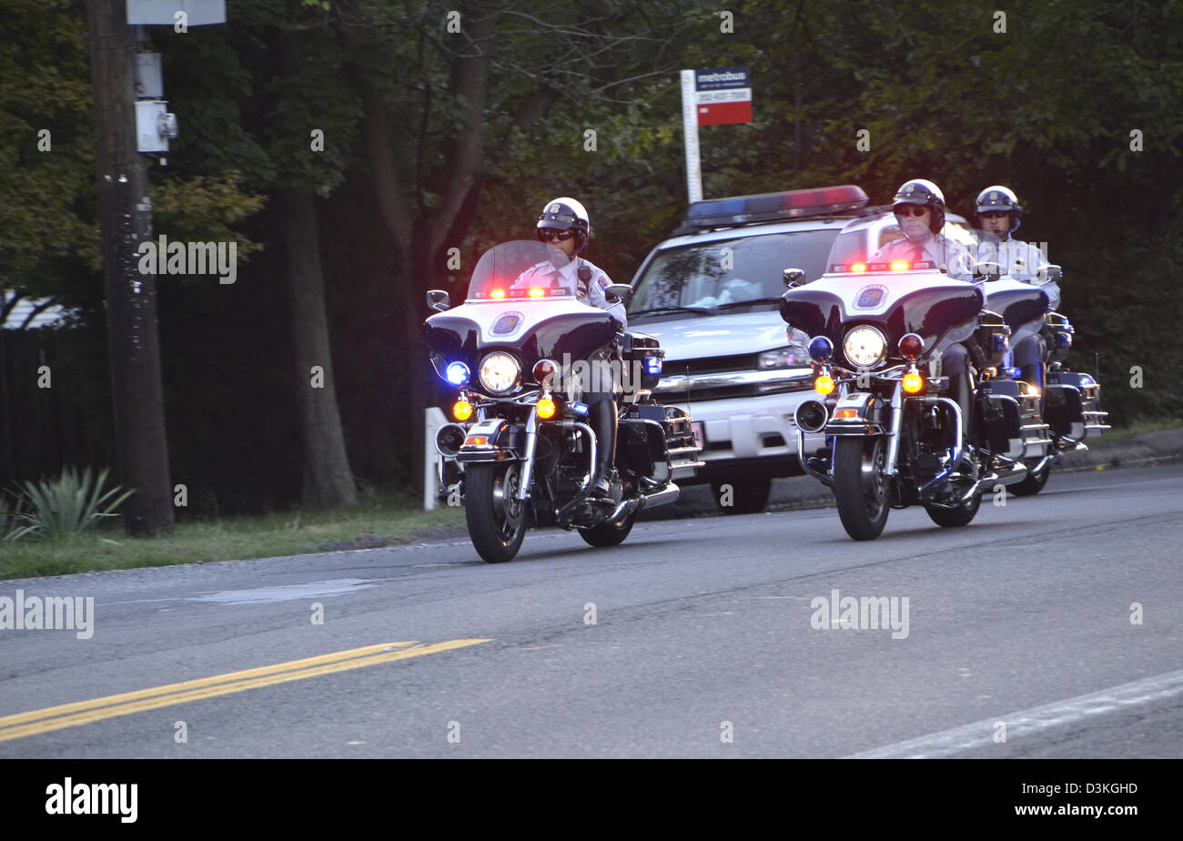 Polizei-Motorräder und ein Kreuzer escort mehrere Fahrzeuge Stockfoto