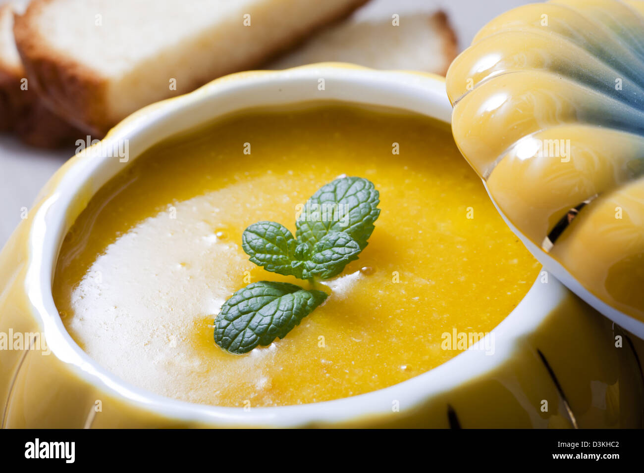 Kürbissuppe in einem Kürbis geformte Schüssel serviert. Stockfoto