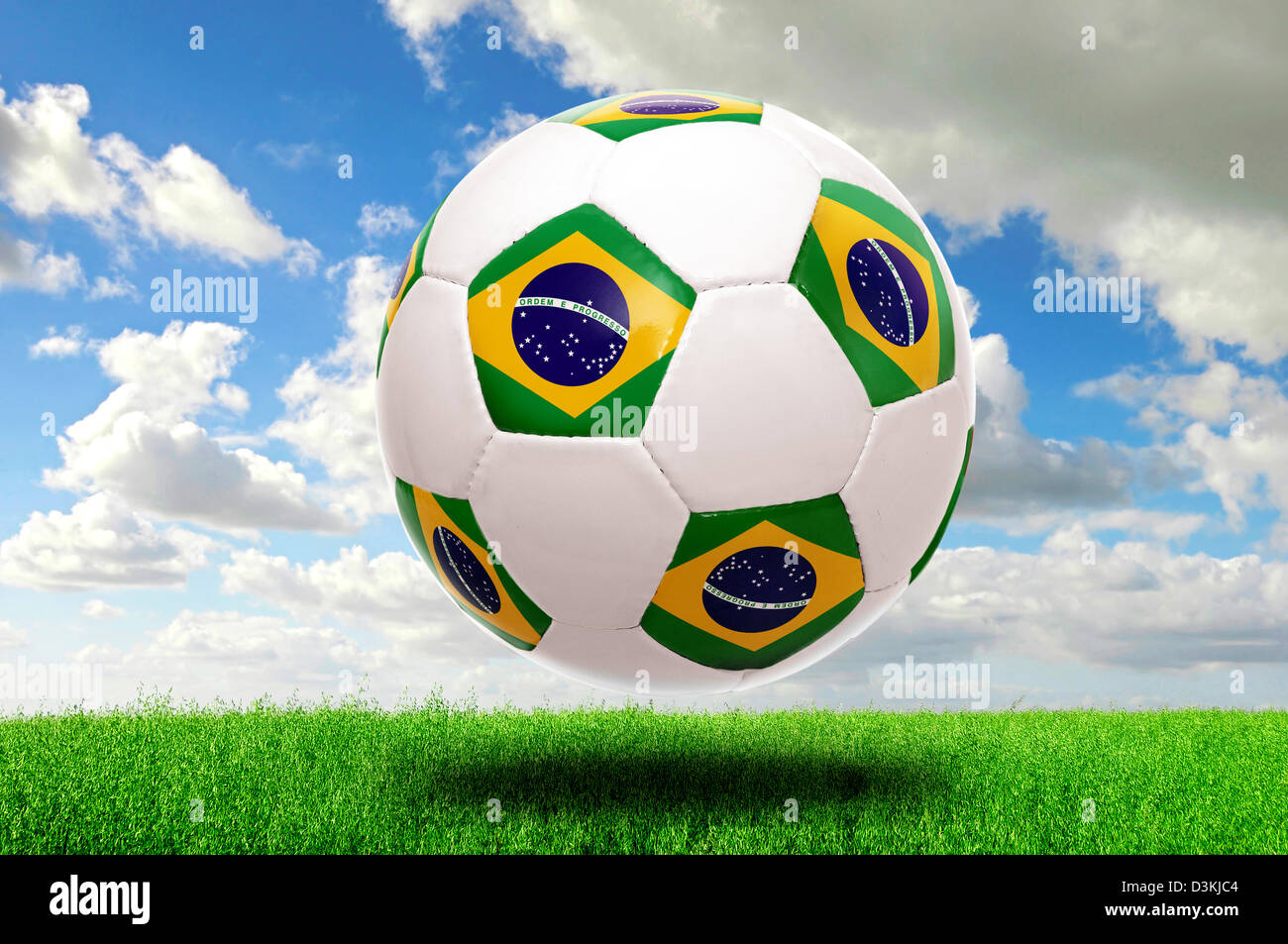 Fußball mit der brasilianischen Flagge in einem grünen Feld Stockfoto