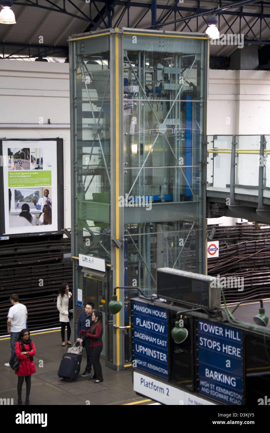 Anheben, um Passagiere zu Plattform & Passagiere warten auf Züge auf der London Underground zu nehmen / u-Bahn am Earls Court station UK Stockfoto