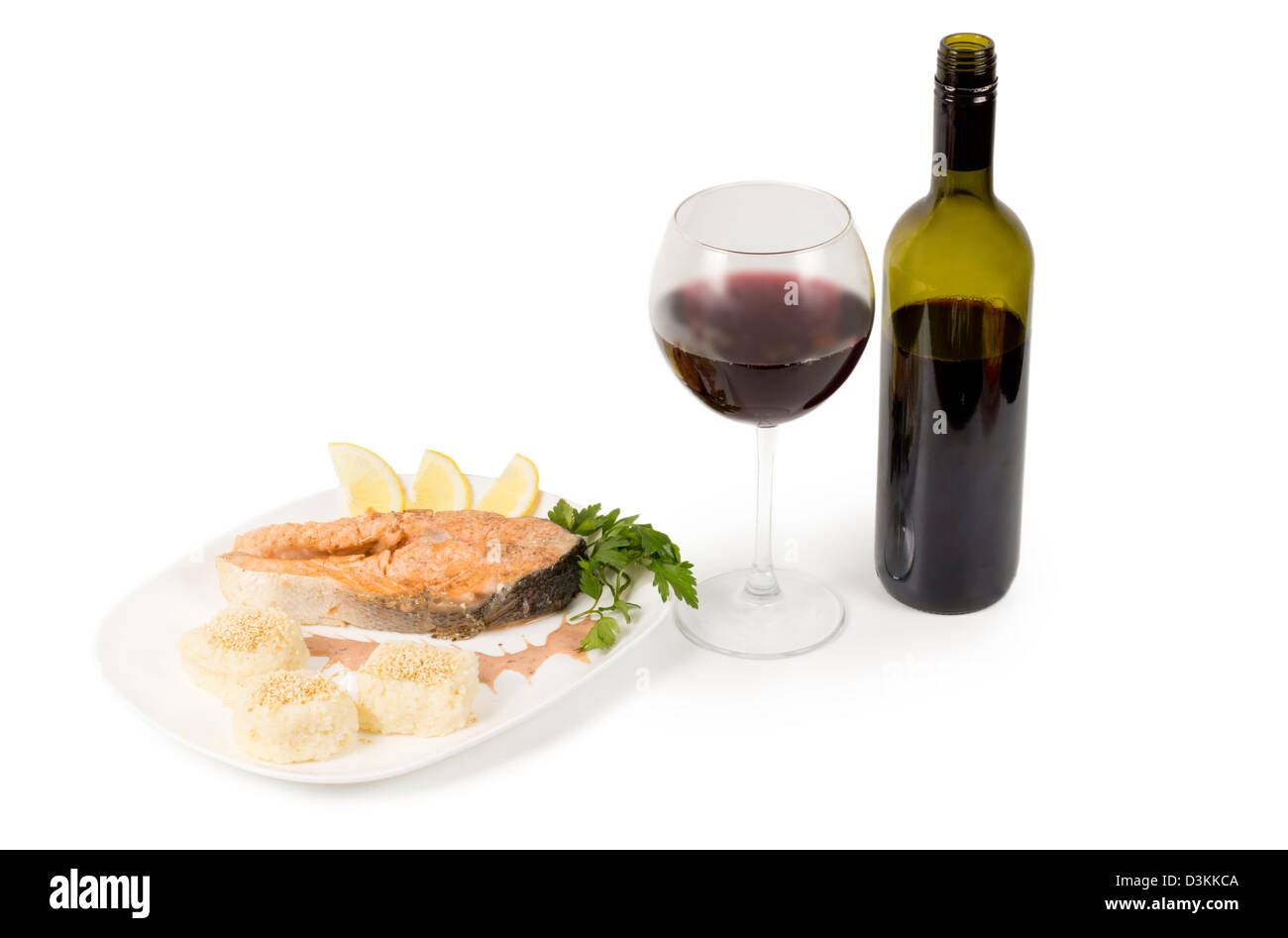 Lecker Lachs Steak serviert mit eine ungekennzeichnete Flasche und Glas Rotwein Stockfoto