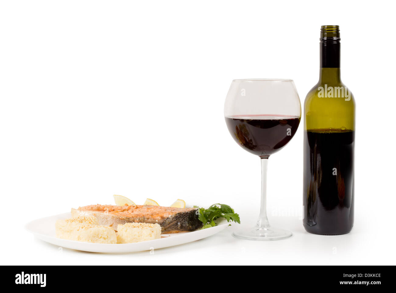 Portion Lachs und Rotwein in ein Weinglas mit eine ungekennzeichnete Flasche neben Stockfoto